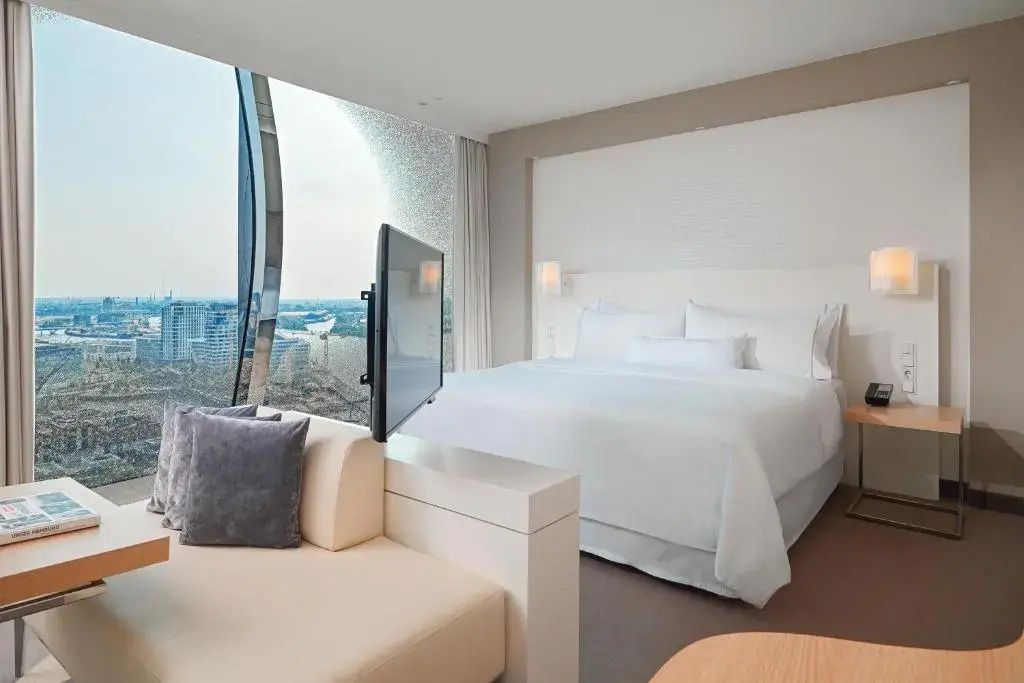 Helles Doppelstudio mit modernem Design und Stadtblick durch große Fenster.