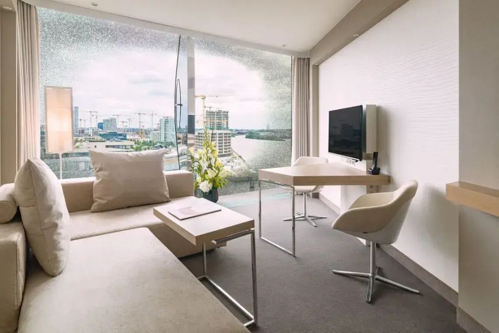 Wohnbereich mit Sofa, Schreibtisch und Panoramablick auf die Stadt