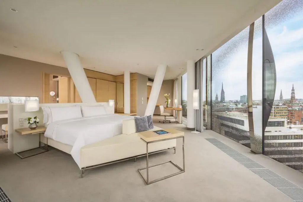 Junior-Suite mit modernem Design und Stadtblick durch große Fenster