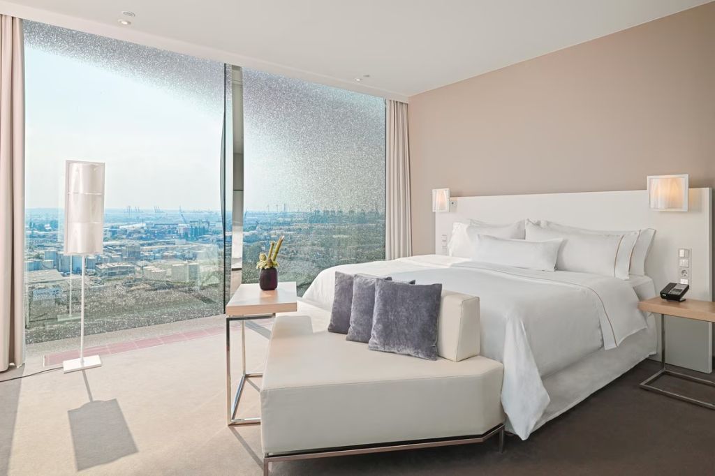 Modernes Hotelzimmer mit Doppelbett und Panoramablick auf die Stadt und das Wasser