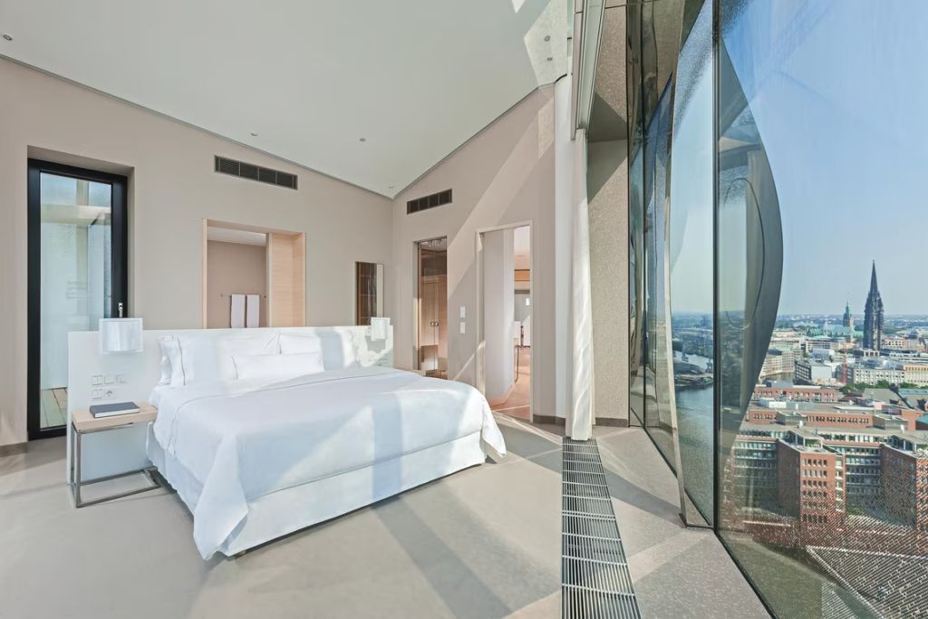 Präsidentensuite mit Doppelbett und großem Fenster mit Ausblick über die Stadt