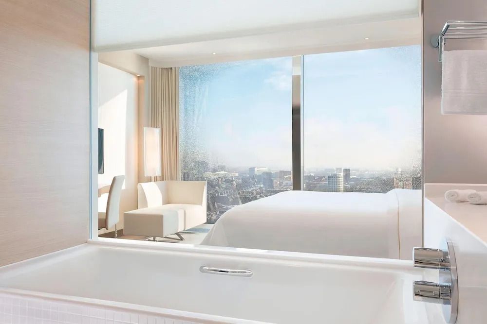 Luxuriöses Badezimmer mit großem Fenster und Blick über die Stadt