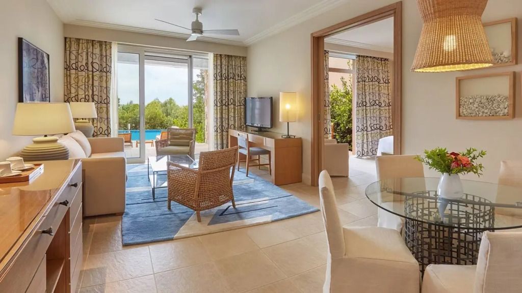 Helles Wohnzimmer mit Sitzbereich und Ausblick auf Pool und Natur