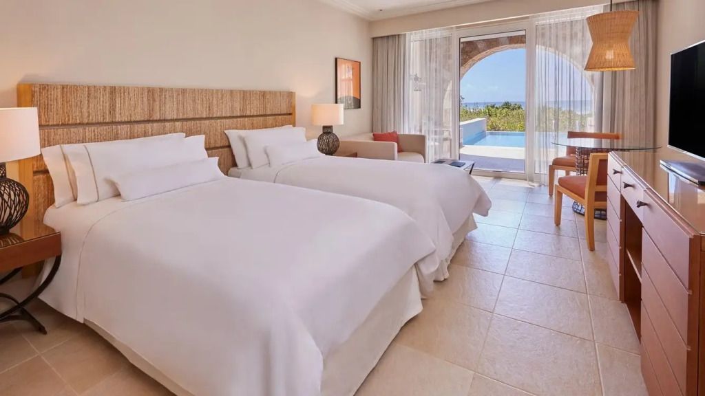 Doppelzimmer mit zwei Einzelbetten, heller Raum und Zugang zu einem privaten Pool