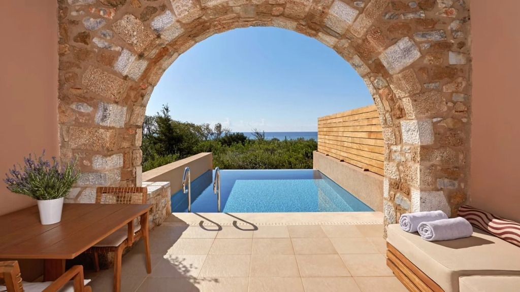 Privater Infinity-Pool mit Meerblick, umgeben von Natur und Steinarchitektur