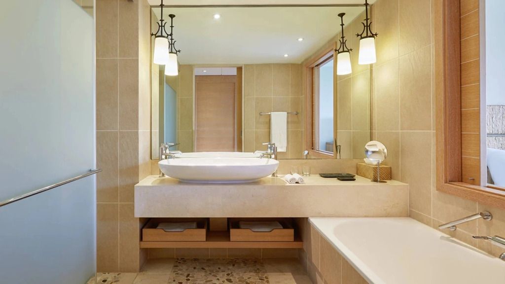 Geräumiges Badezimmer mit großem Spiegel und eleganten Leuchten