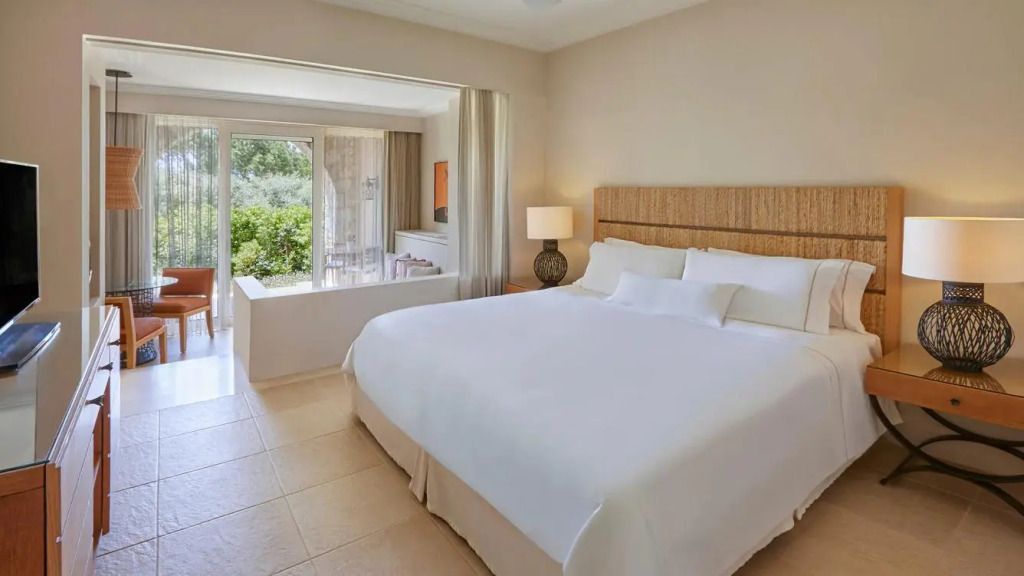 Helles Superior Doppelzimmer mit großer Glasfront und Blick in den Garten.
