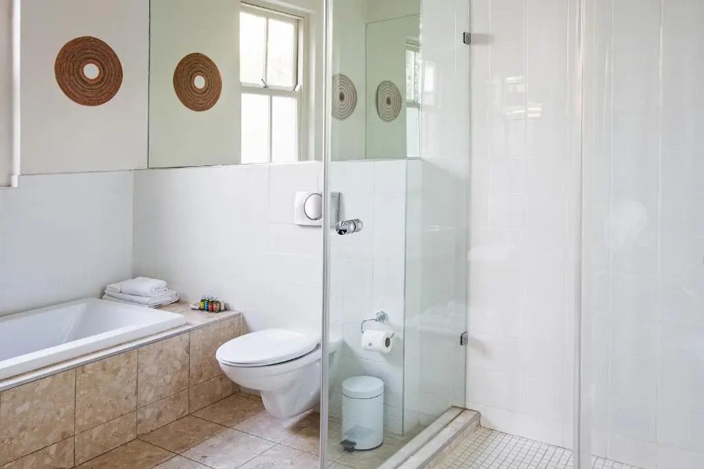 Modernes Badezimmer mit weißer Keramik und Glasdusche