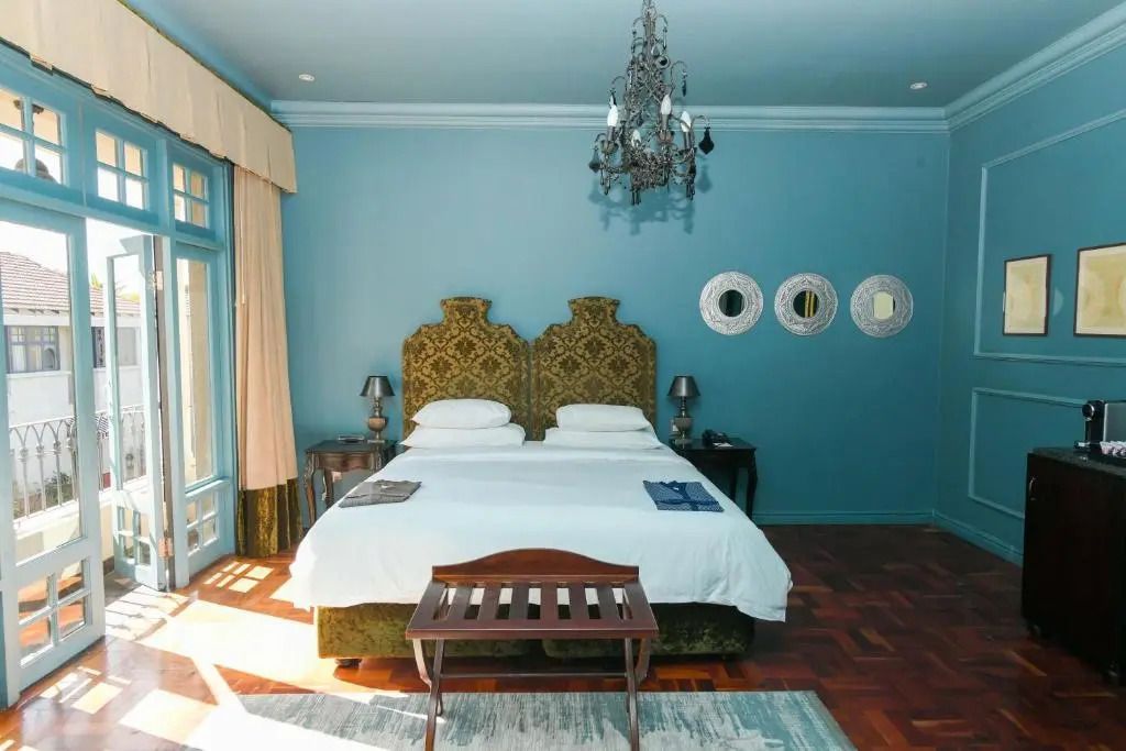 Geräumiges Schlafzimmer mit großem Bett und dekorativen Spiegeln