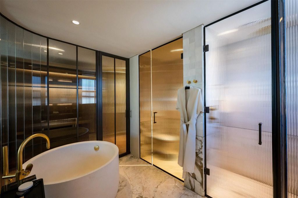 Luxuriöses Badezimmer mit freistehender Badewanne und Designer-Duschwänden