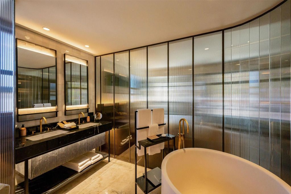 Modernes Badezimmer mit großer Badewanne und goldenen Details