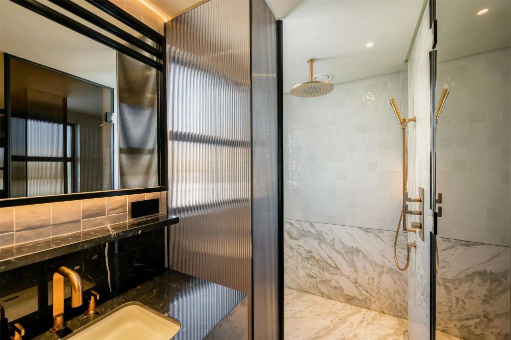 Moderne Dusche mit Regenduschkopf in marmorgefliestem Badezimmer