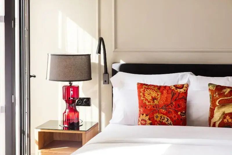 Komfortables Bett mit bunter Kissen, eingebautem Leselicht und Nachttischlampe