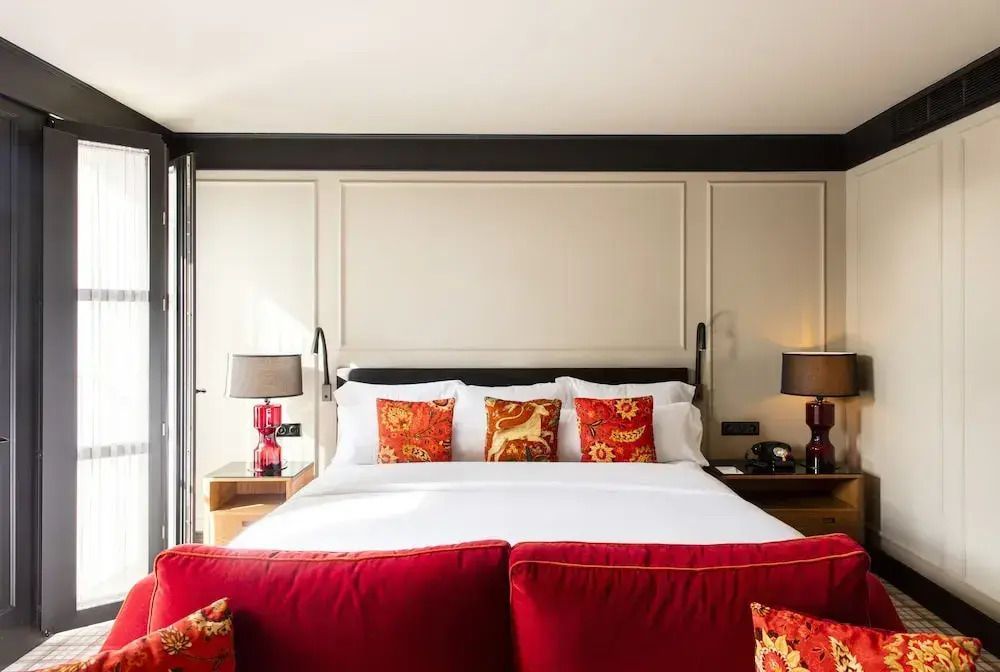 Komfortables Bett mit eleganten rot-gemusterten Kissen in der Junior-Suite
