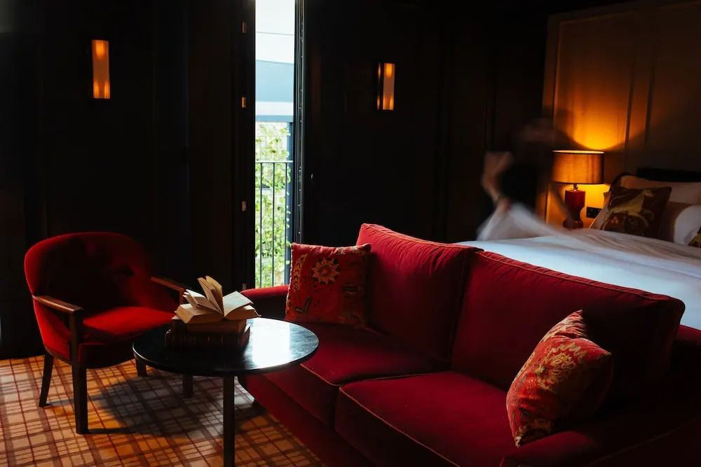 Gemütliche Sitzecke mit rotem Sofa und Balkonblick in der Junior-Suite