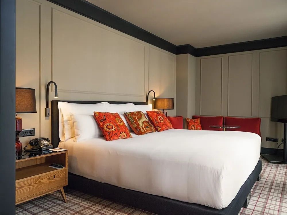 Gemütliches Hotelzimmer mit Kingsize-Bett und farbenfrohen Kissen