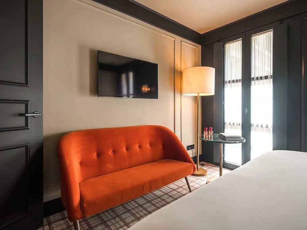 Orangefarbene Couch im Zimmer mit Flachbildfernseher