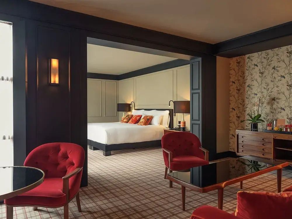 Luxuriöses Schlafzimmer mit roten Sesseln und gemütlichem Bett