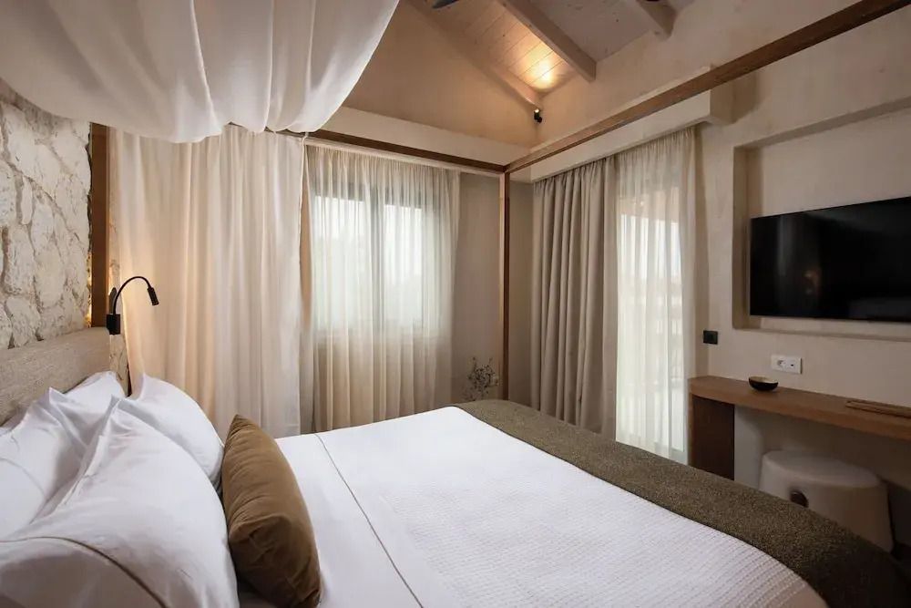 Gemütliches Schlafzimmer der Suite mit bodenlangen Vorhängen.