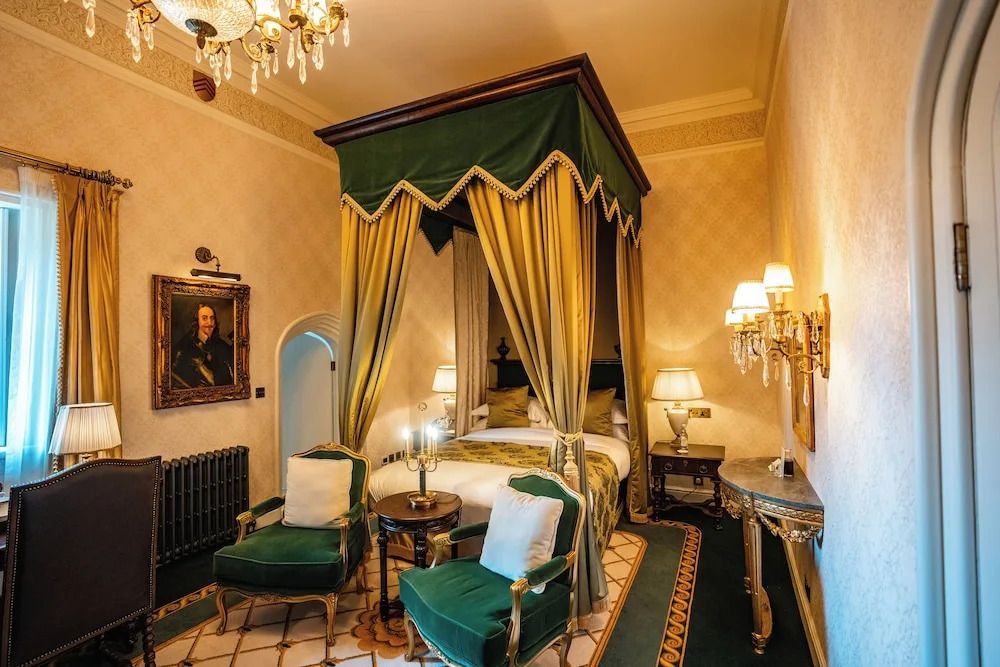 Prunkvolles Himmelbett mit grün-goldenem Vorhang und antiken Möbeln