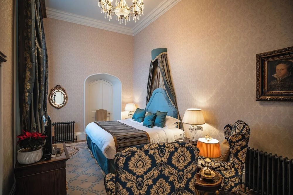 Luxuriöses Doppelzimmer mit elegantem Kronleuchter und stilvollen Sitzmöbeln
