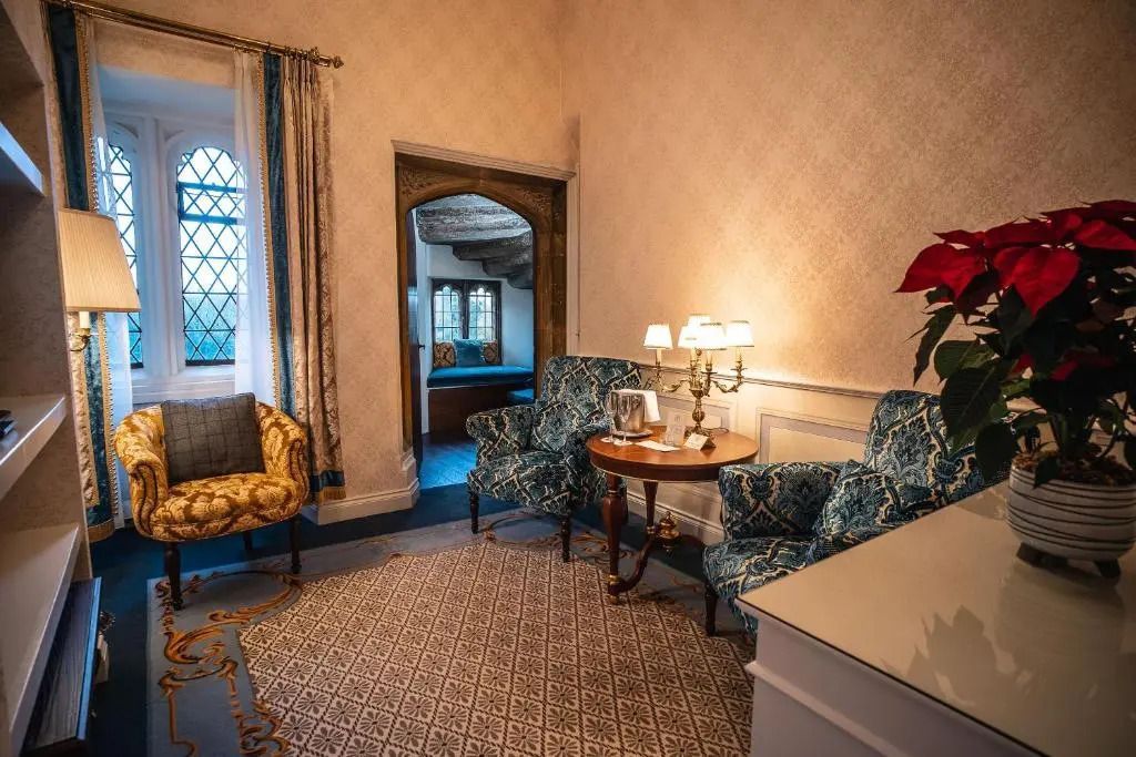 Wohnbereich der Deluxe Suite mit eleganten Sesseln und dekorativem Fenster.