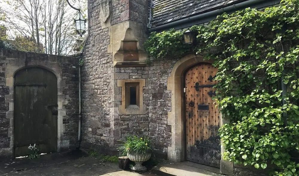 Detailreicher Eingang mit steinverzierter Fassade und Eisentor im Thornbury Castle Hotel