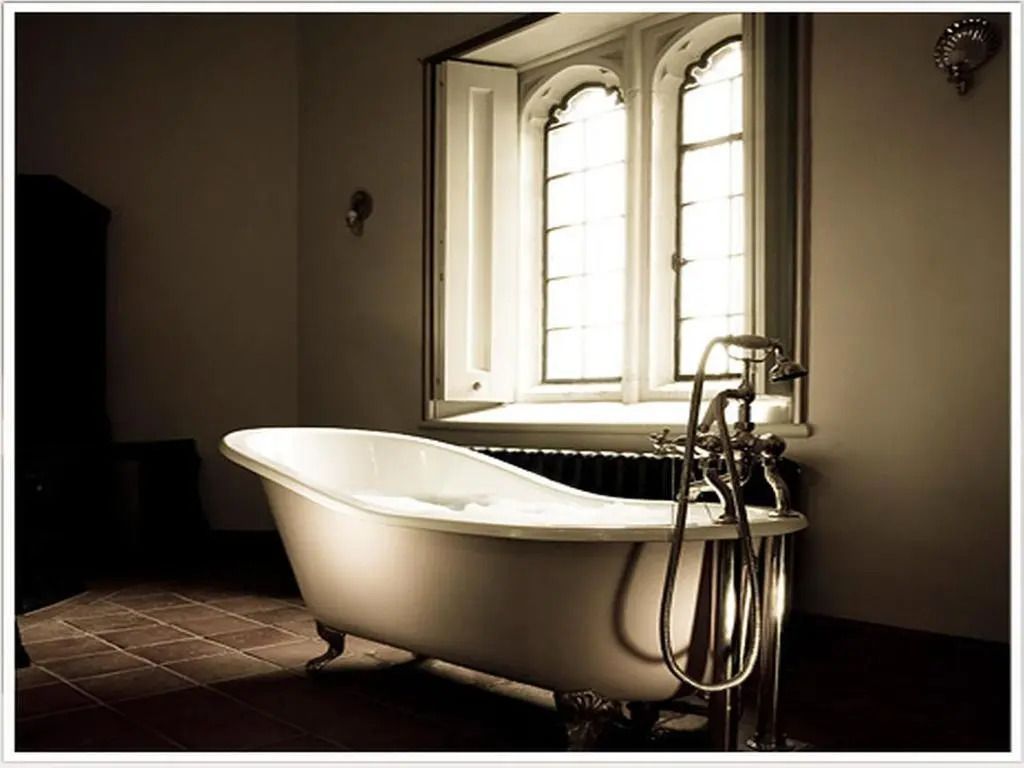 Elegante freistehende Badewanne vor einem gotischen Fenster