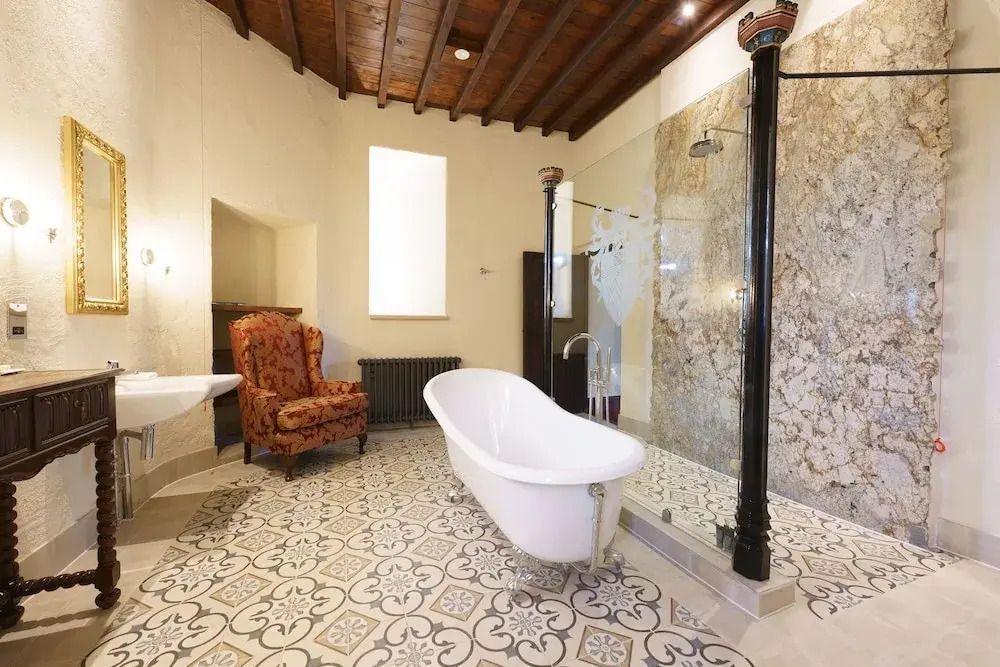 Badezimmer mit freistehender Badewanne und aufwendigen Fliesenmustern.