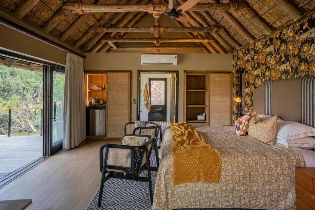 Gemütliches Schlafzimmer in der Luxus Suite mit Strohdach und warmen Farben