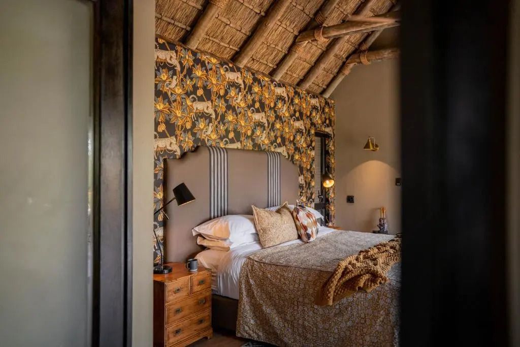 Stilvoll eingerichtetes Schlafzimmer mit einzigartiger Tapete und Strohdach