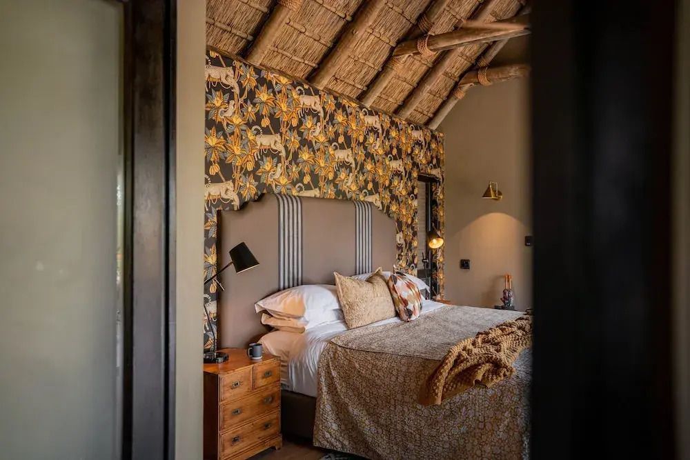 Gemütliches Schlafzimmer mit dekorativer Tapete und Holzakzenten.