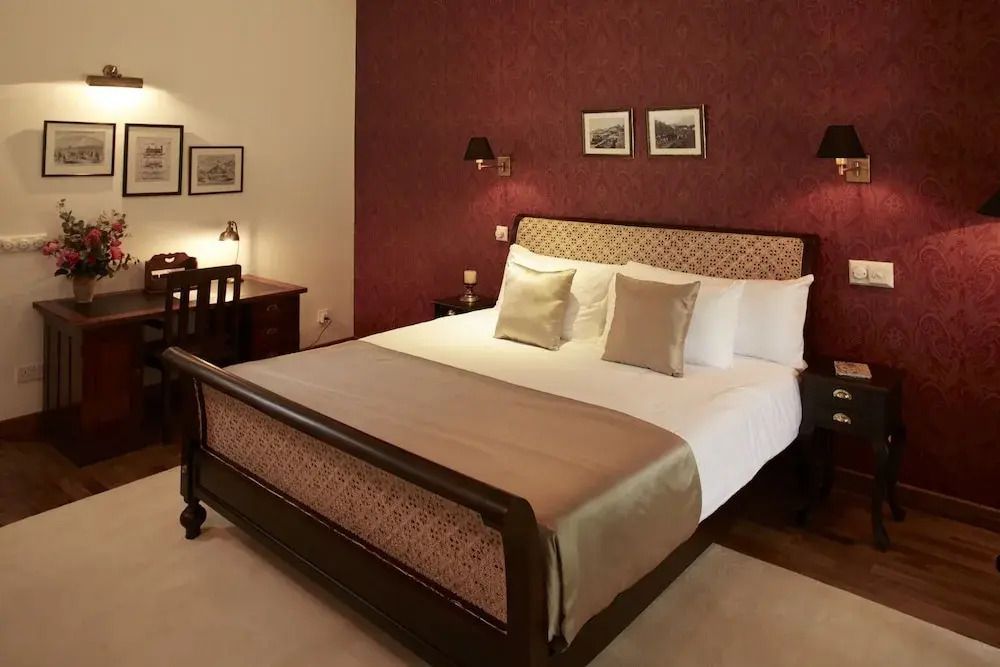 Geräumiges Zimmer mit Doppelbett und Holzmöbeln