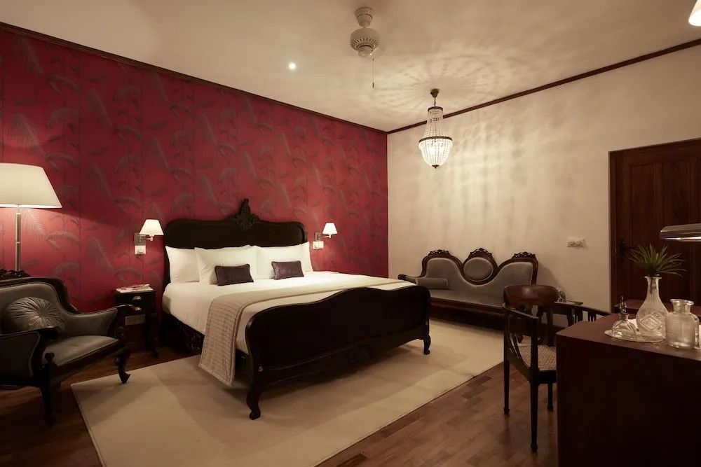 Opulentes Schlafzimmer mit elegantem Leuchter und Sessel