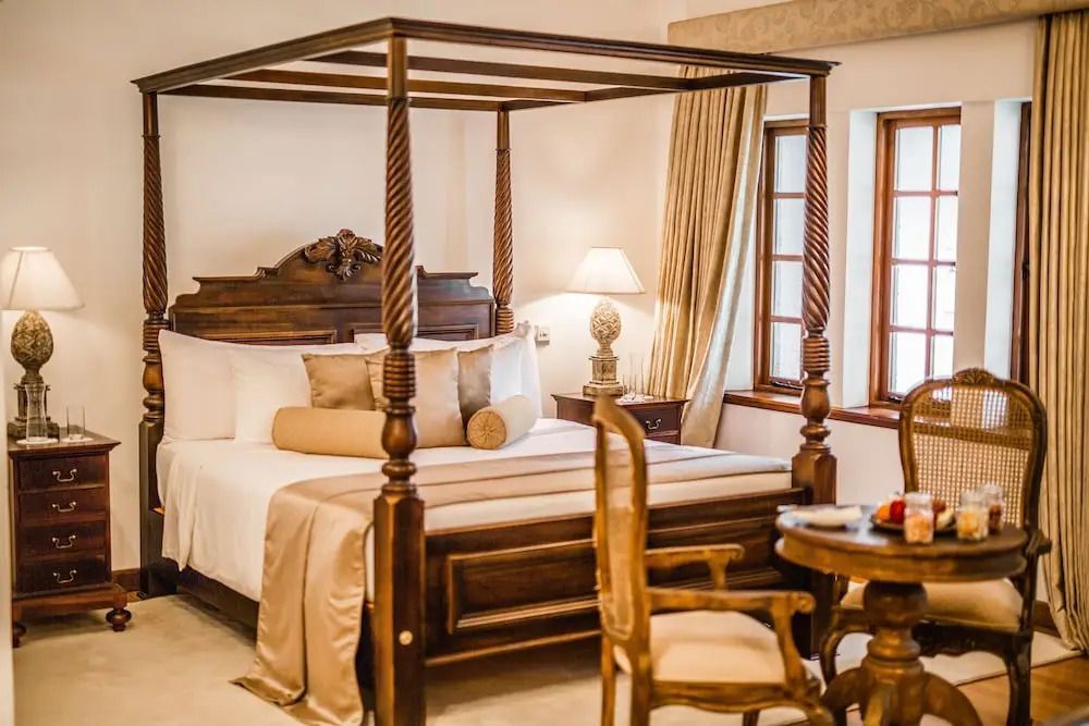 Luxuriöses Schlafzimmer mit Himmelbett und stilvollen Holzmöbeln