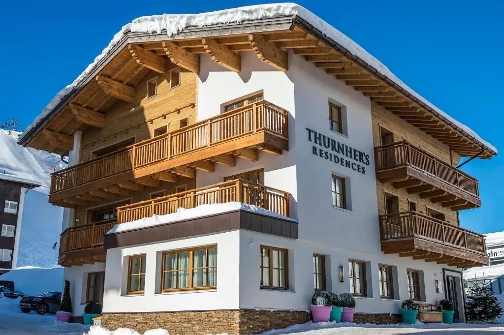 Außenansicht des Thurnher's Residences im Winter mit Holzbalkonen