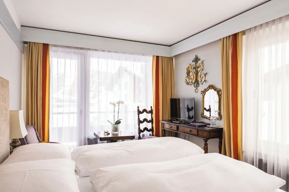 Gemütliches Doppelzimmer mit großen Fenstern und eleganter Einrichtung