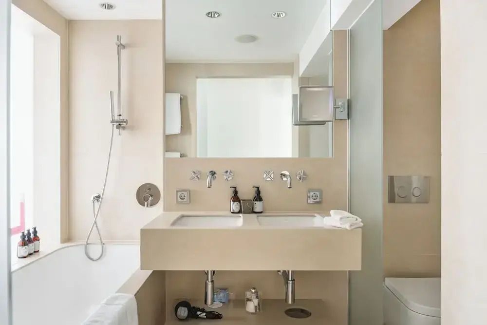 Modernes Badezimmer mit zwei Waschbecken und Duschbad in sanften Farben.