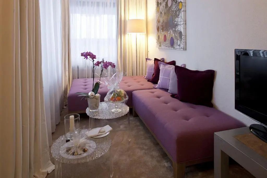 Gemütlicher Sitzbereich mit lila Sofas und dekorativen Kissen