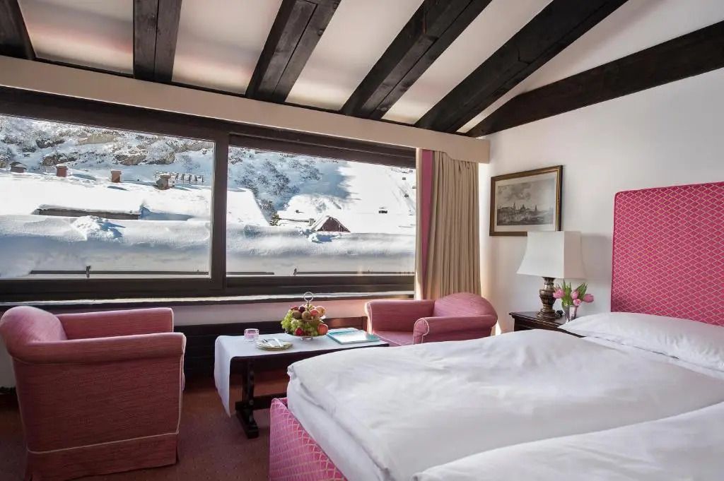 Helles Schlafzimmer mit traditionellem Dekor und großem Fenster mit Bergblick