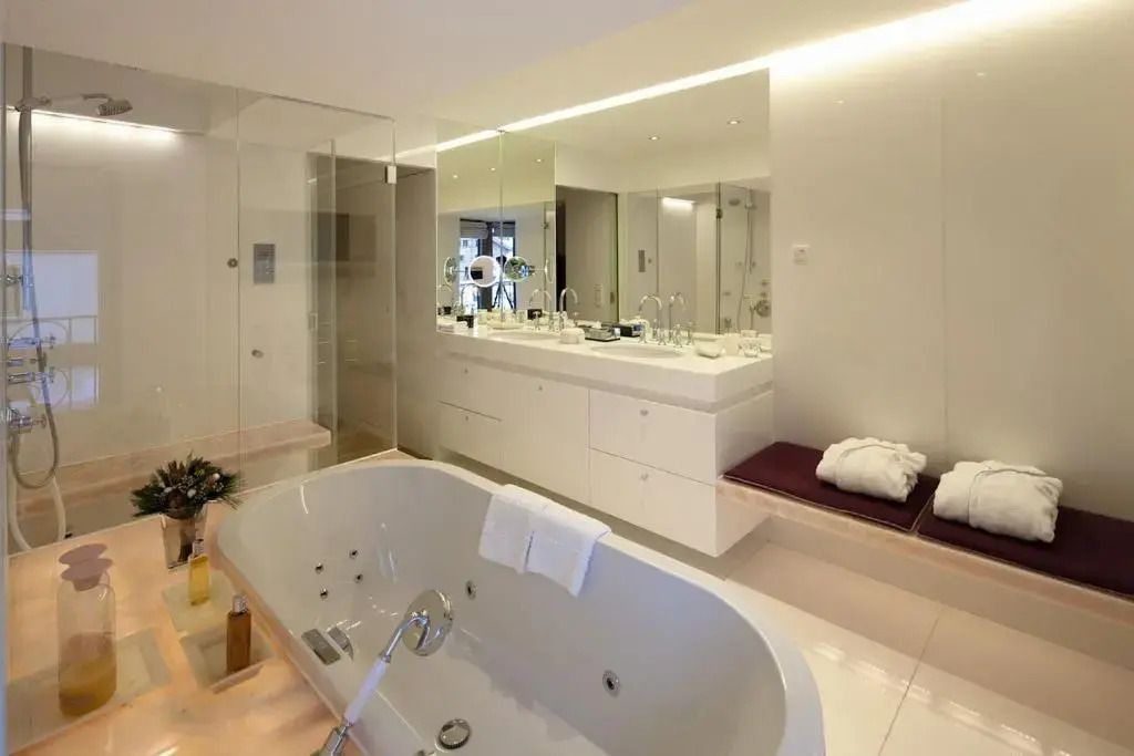 Großes Badezimmer mit Badewanne und moderner Einrichtung in Suite
