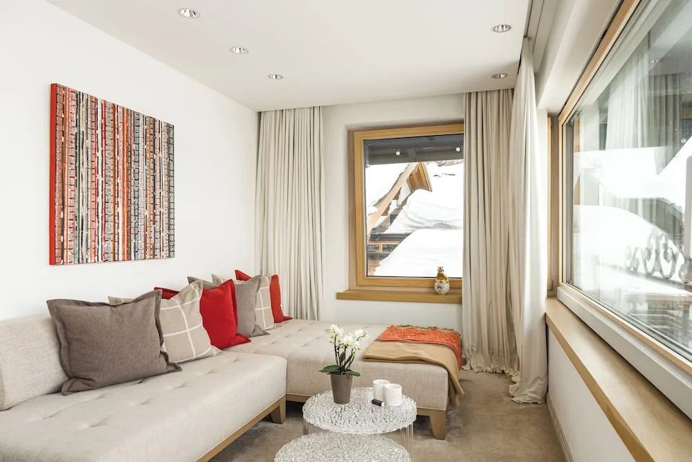 Helles Zimmer mit stilvollen Möbeln und Blick auf die verschneiten Berge.