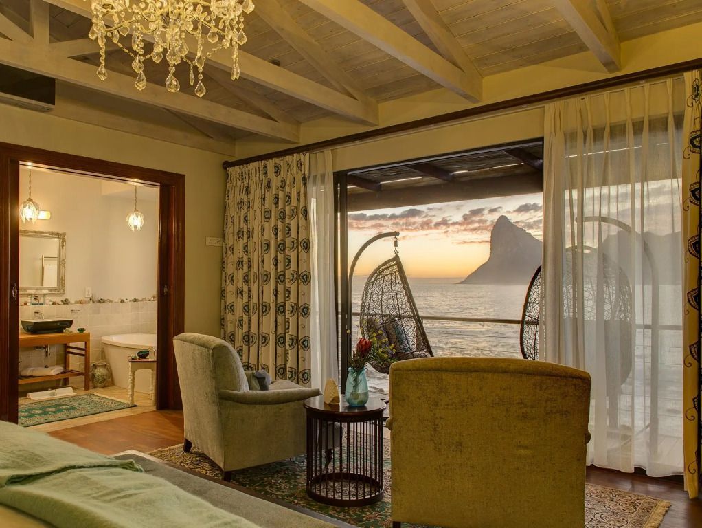Luxuriöses Zimmer mit Blick auf Meer und Berge durch große Fenster
