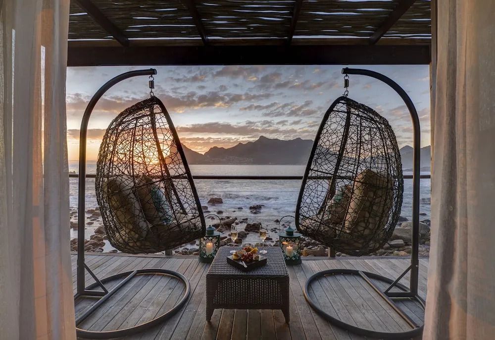 Terrasse mit zwei hängenden Sesseln und Blick auf das Meer