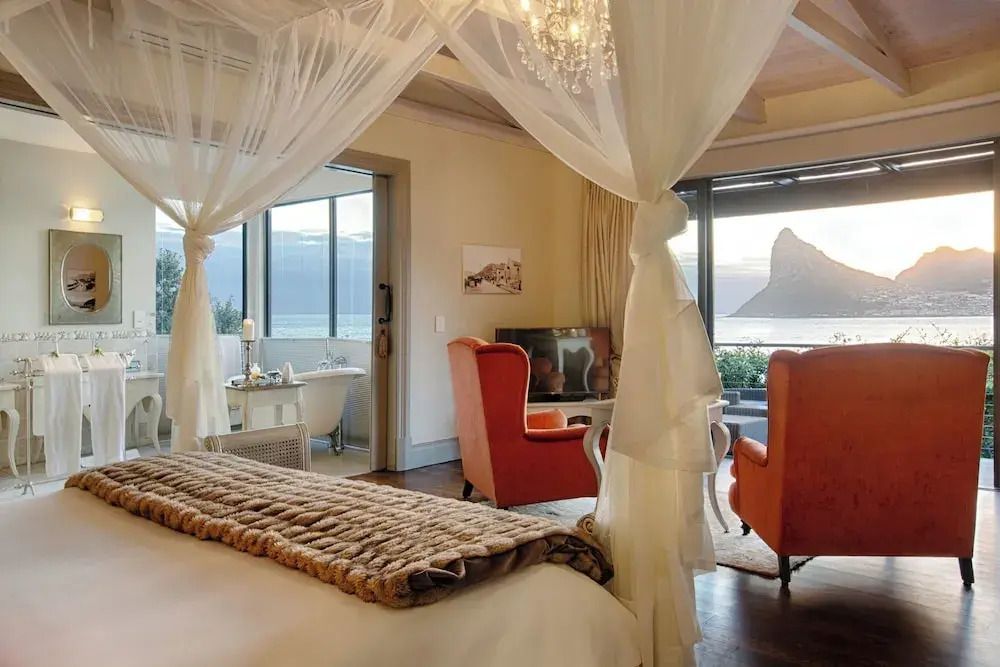 Romantischer Raum mit Himmelbett und großem Fenster zum Meer