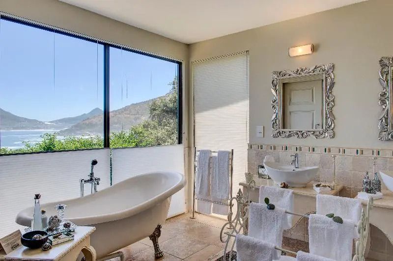 Helles Badezimmer mit freistehender Badewanne und großem Fenster mit Aussicht.