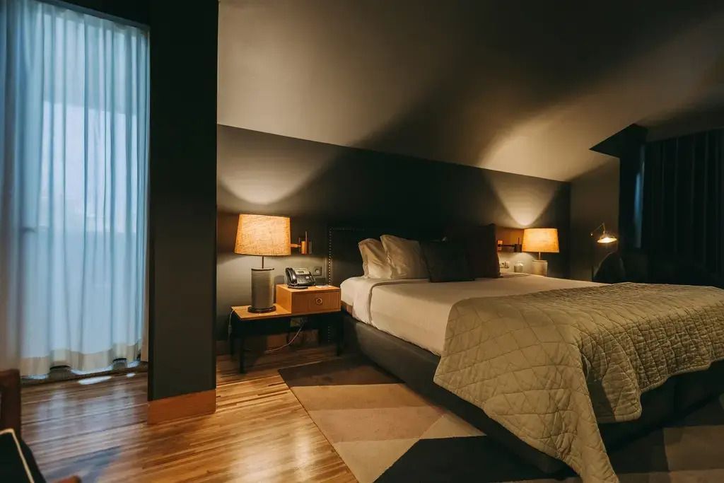 Gemütliches Schlafzimmer in dunklen Tönen mit Beleuchtung und modernem Dekor