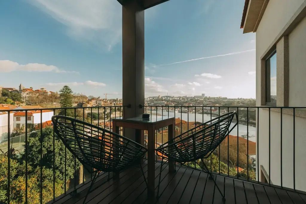 Balkon mit zwei Stühlen und Tisch mit Blick auf den Fluss und die Stadt