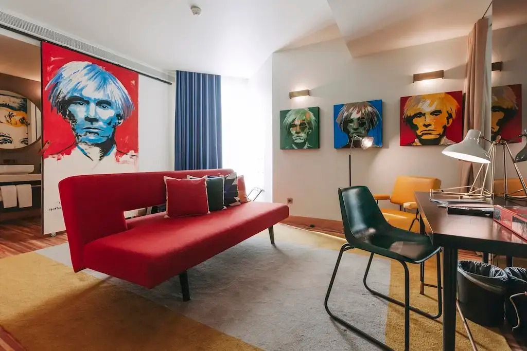 Künstlerischer Wohnbereich mit farbenfrohen Gemälden und modernem Sofa