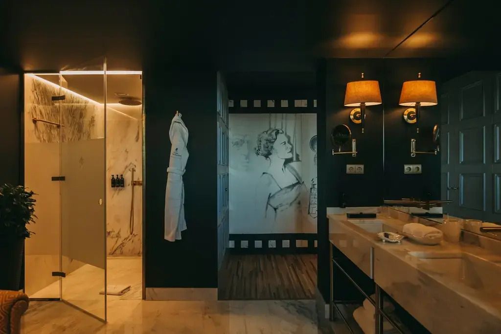 Modernes Badezimmer mit Marmorboden und großem Spiegel im Hotel Torel Avantgarde